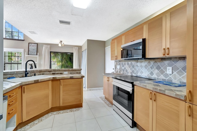kitchen featuring electric range, a sink, backsplash, light tile patterned floors, and plenty of natural light