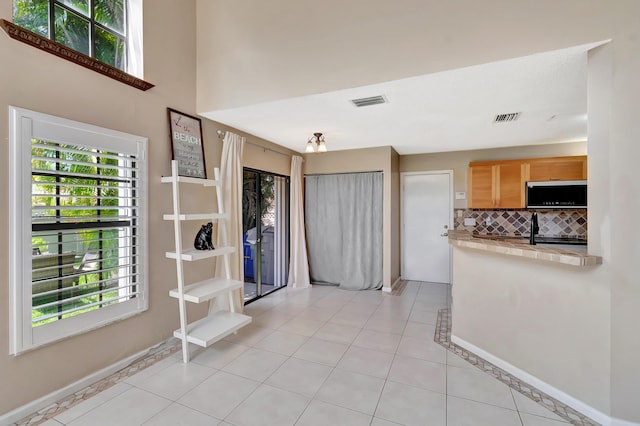 entryway featuring plenty of natural light, baseboards, and light tile patterned flooring