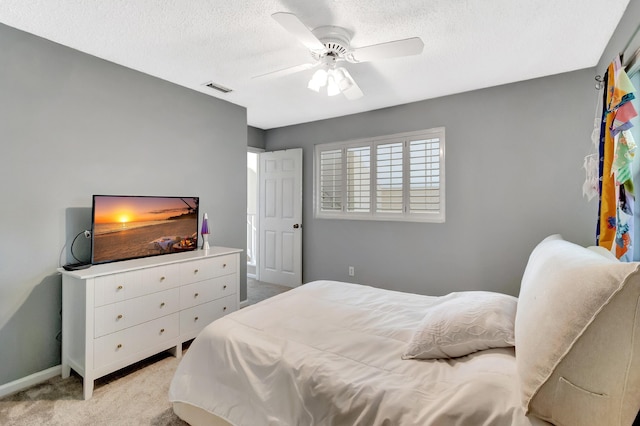 carpeted bedroom featuring a textured ceiling, ceiling fan, and baseboards