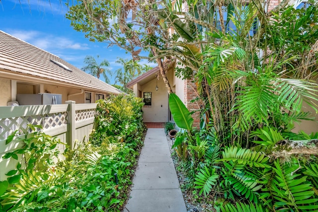 doorway to property with stucco siding and fence