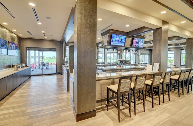 bar with light wood finished floors and recessed lighting