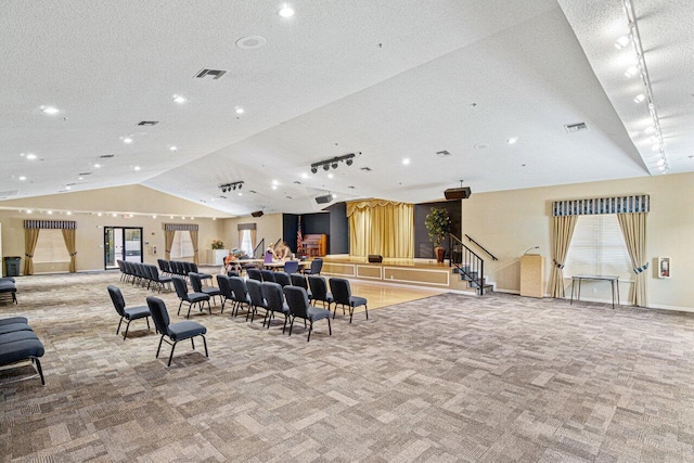 building lobby featuring lofted ceiling, stairway, a textured ceiling, and recessed lighting