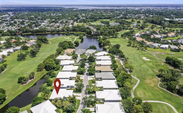 view of property location featuring a nearby body of water, nearby suburban area, and a golf course