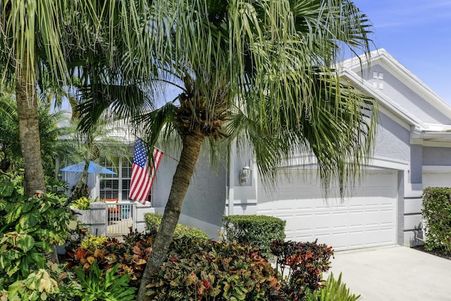 view of front of home featuring a garage, concrete driveway, and stucco siding