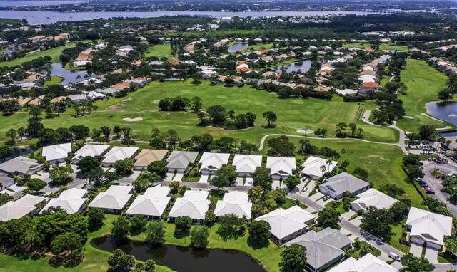 aerial view of property and surrounding area with nearby suburban area, a nearby body of water, and a golf course