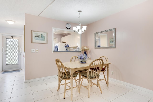 2151 NE 1st Ct Unit 102, Boynton Beach, FL 33435 - dining space with a chandelier, baseboards, and light tile patterned floors