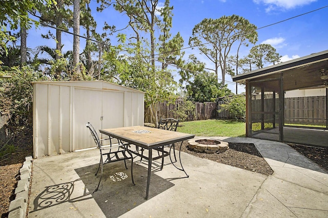 view of patio with a storage shed, an outdoor fire pit, an outbuilding, and outdoor dining space