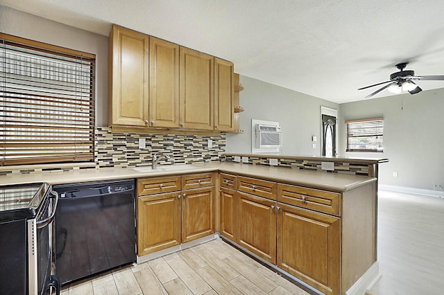 kitchen with black dishwasher, a peninsula, a sink, and decorative backsplash