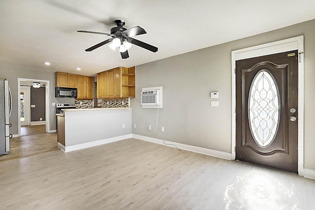 entryway featuring a ceiling fan, light wood-style floors, baseboards, a wall mounted AC, and recessed lighting