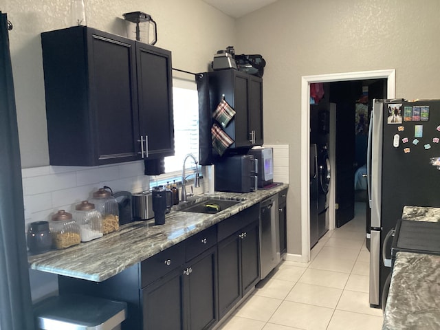 3834 SE 12th Dr, Okeechobee, FL 34974 - kitchen with a sink, appliances with stainless steel finishes, light tile patterned floors, washer / clothes dryer, and decorative backsplash
