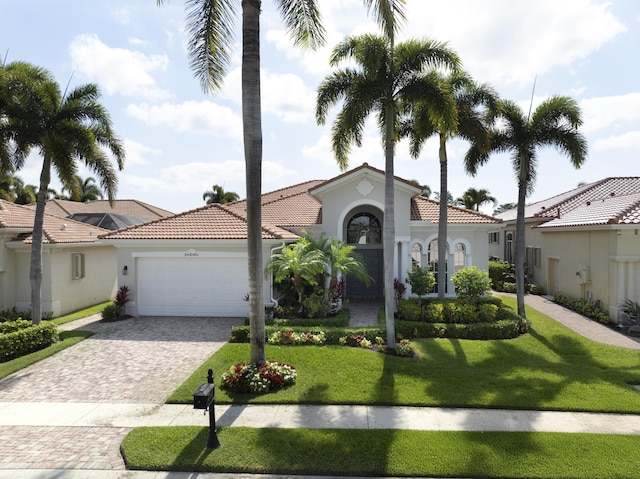 212 Montant Dr, Palm Beach Gardens, FL 33410 - mediterranean / spanish-style house featuring a tile roof, an attached garage, stucco siding, decorative driveway, and a front yard