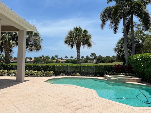 view of swimming pool featuring a patio area, fence, and a pool with connected hot tub