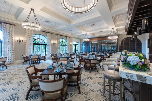 carpeted dining area with coffered ceiling, a chandelier, ornamental molding, beam ceiling, and baseboards