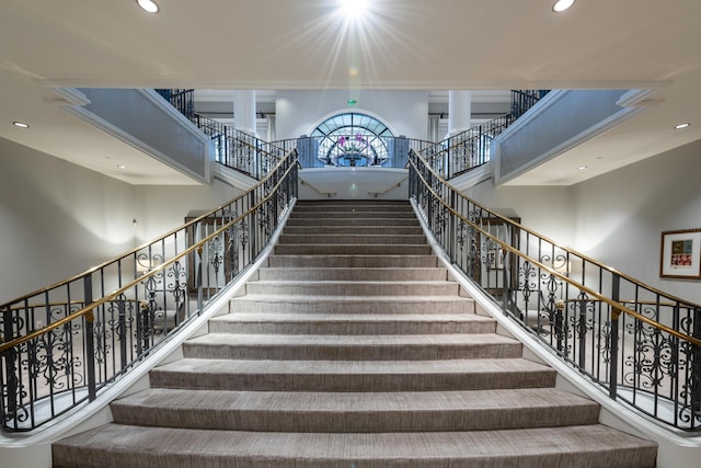 stairway featuring recessed lighting and a high ceiling