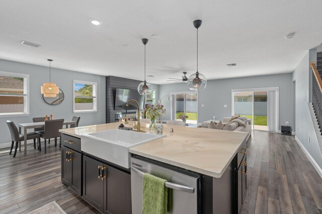 412 SW Dailey Ave, Port Saint Lucie, FL 34953 - kitchen featuring stainless steel dishwasher, a sink, open floor plan, a center island with sink, and dark wood-style floors