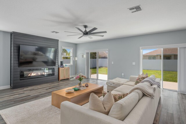 412 SW Dailey Ave, Port Saint Lucie, FL 34953 - living room with wood finished floors, a fireplace, a ceiling fan, and baseboards