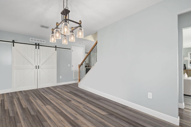 412 SW Dailey Ave, Port Saint Lucie, FL 34953 - unfurnished dining area featuring dark wood-type flooring, a barn door, and baseboards