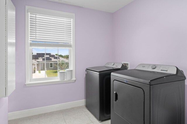 412 SW Dailey Ave, Port Saint Lucie, FL 34953 - laundry area with washing machine and dryer, baseboards, and light tile patterned floors