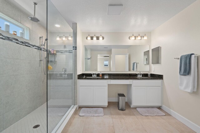 412 SW Dailey Ave, Port Saint Lucie, FL 34953 - full bath with tiled shower, double vanity, a textured ceiling, and baseboards