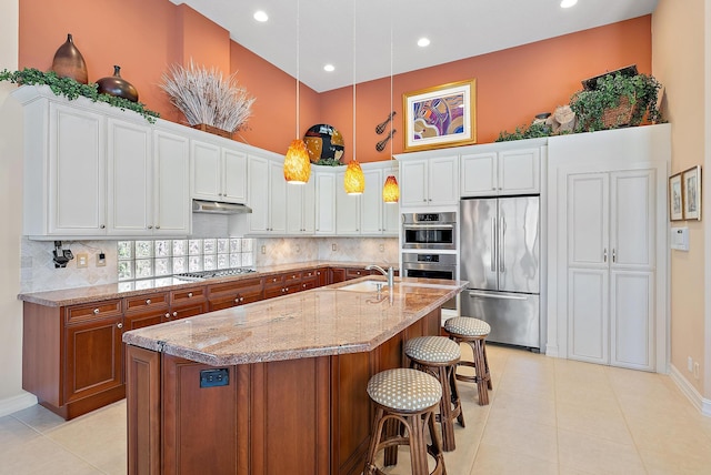 7731 Blue Heron Way, West Palm Beach, FL 33412 - kitchen featuring stainless steel appliances, a towering ceiling, a sink, light stone countertops, and recessed lighting