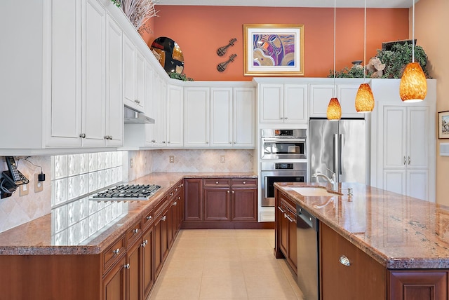 7731 Blue Heron Way, West Palm Beach, FL 33412 - kitchen featuring a sink, appliances with stainless steel finishes, under cabinet range hood, tasteful backsplash, and light stone countertops