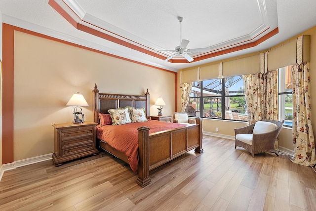 7731 Blue Heron Way, West Palm Beach, FL 33412 - bedroom with a tray ceiling, ornamental molding, light wood-style flooring, baseboards, and a ceiling fan