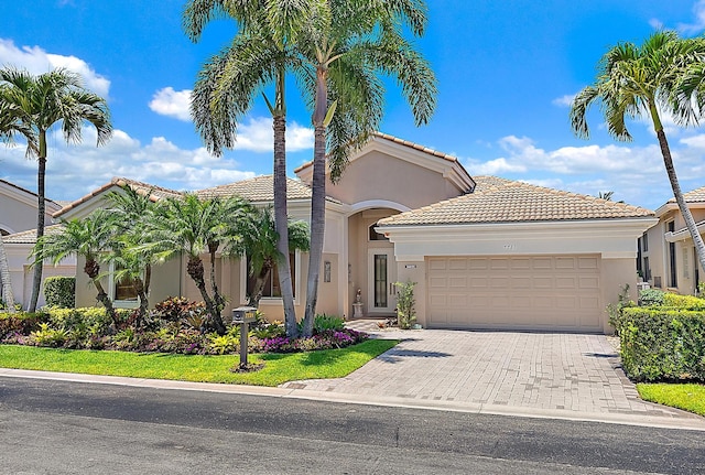 7731 Blue Heron Way, West Palm Beach, FL 33412 - mediterranean / spanish-style house with an attached garage, stucco siding, a tile roof, and driveway