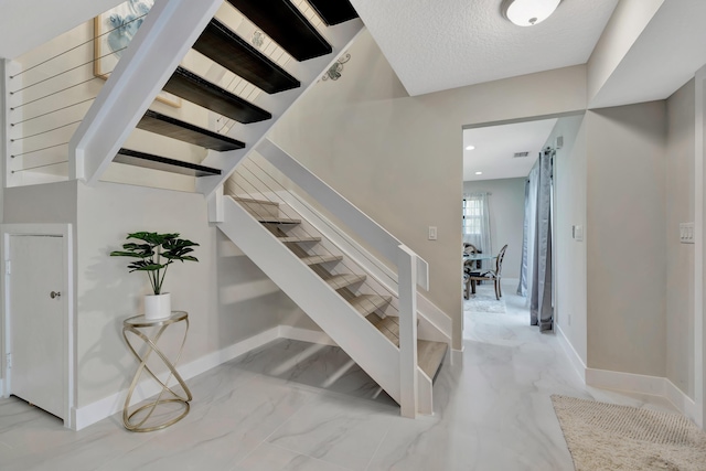 stairway with marble finish flooring and baseboards