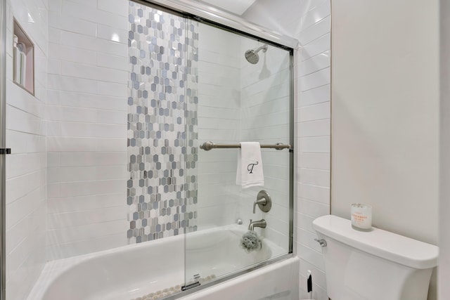 bathroom featuring shower / bath combination with glass door and toilet