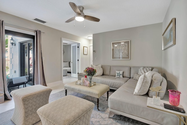 living room with ceiling fan and baseboards
