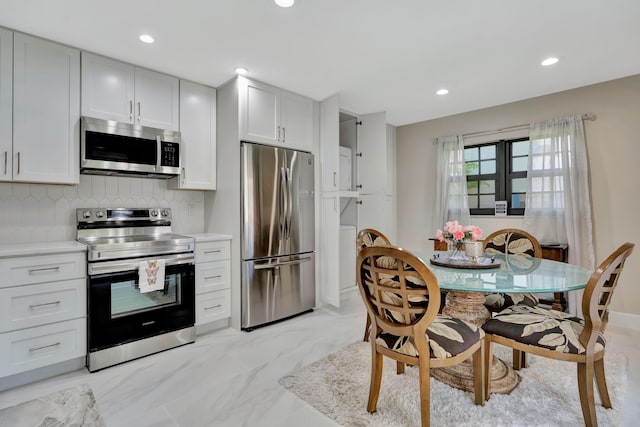 kitchen featuring stainless steel appliances, decorative backsplash, light countertops, recessed lighting, and light marble finish floors