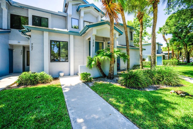 doorway to property with stucco siding and a yard