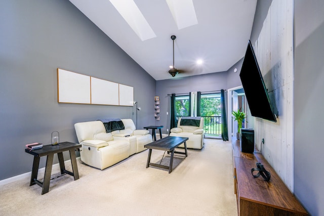 living area with a skylight, light colored carpet, and high vaulted ceiling