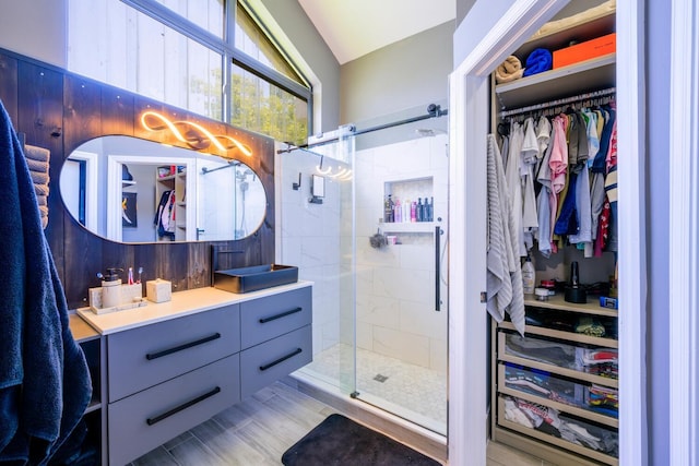 full bath with a shower stall, vanity, and a spacious closet