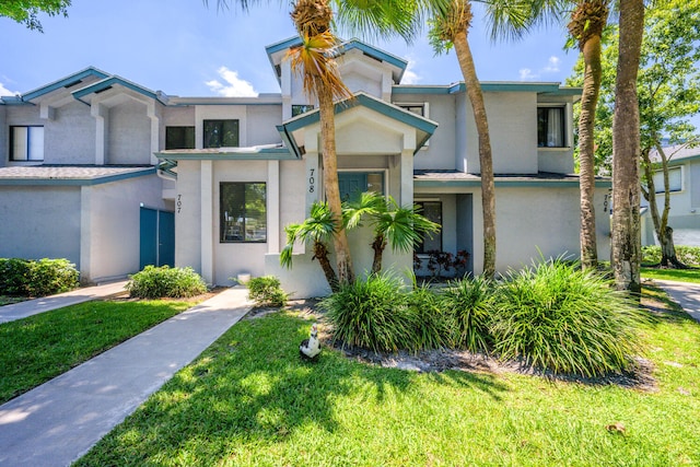 view of front of property featuring stucco siding and a front yard