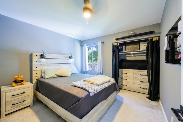 bedroom featuring light colored carpet and a ceiling fan