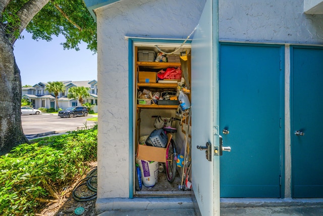 view of exterior entry with stucco siding and uncovered parking