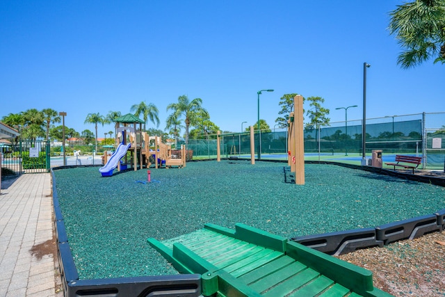 community jungle gym featuring fence and a tennis court