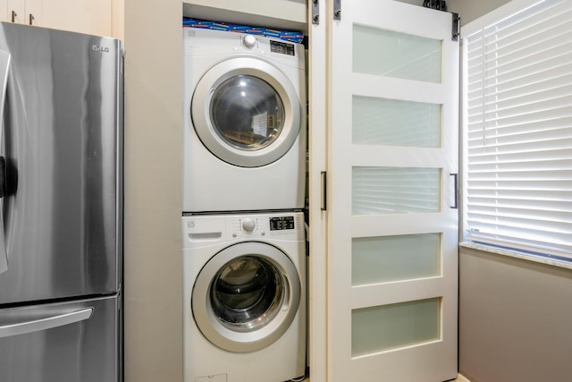 laundry area featuring stacked washer / drying machine