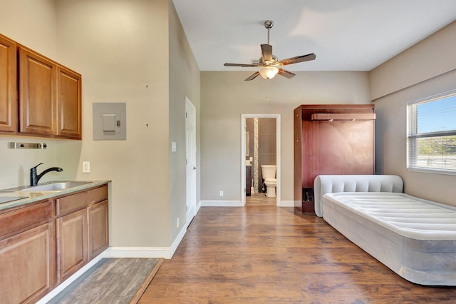 16888 W Downers Dr W, The Acreage, FL 33470 - bedroom with electric panel, a sink, wood finished floors, ensuite bathroom, and baseboards
