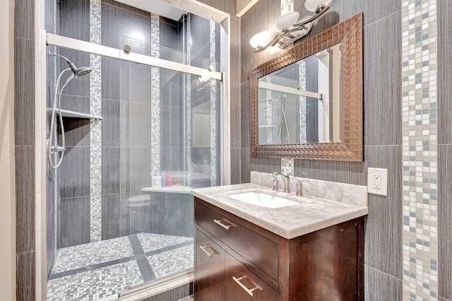 16888 W Downers Dr W, The Acreage, FL 33470 - bathroom featuring a shower stall, vanity, and tile walls