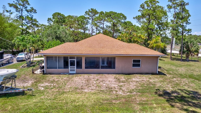16888 W Downers Dr W, The Acreage, FL 33470 - rear view of property with a sunroom, a yard, a shingled roof, and view of scattered trees