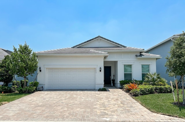 9865 SW Meridian Way, Stuart, FL 34997 - view of front of house featuring decorative driveway, a garage, and stucco siding