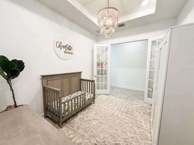 9865 SW Meridian Way, Stuart, FL 34997 - carpeted bedroom featuring a chandelier, a tray ceiling, and french doors