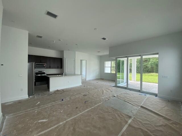 9865 SW Meridian Way, Stuart, FL 34997 - unfurnished living room with baseboards