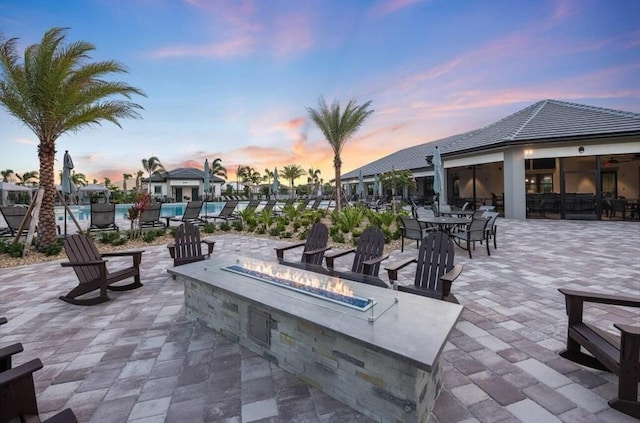 9865 SW Meridian Way, Stuart, FL 34997 - patio terrace at dusk with a fire pit, a swimming pool, and a patio