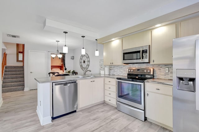 5201 Wheatley Ct, Boynton Beach, FL 33436 - kitchen featuring appliances with stainless steel finishes, a sink, a peninsula, light countertops, and cream cabinets