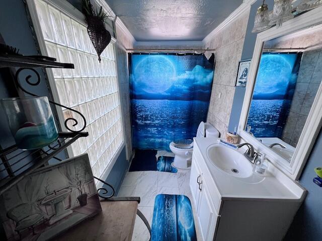 4928 Jefferson Rd, Delray Beach, FL 33445 - bathroom with vanity, tile walls, toilet, crown molding, and a shower with shower curtain
