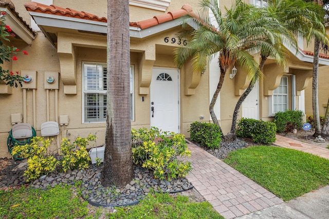 6936 Stoney Creek Cir, Lake Worth, FL 33467 - doorway to property featuring stucco siding and a tile roof