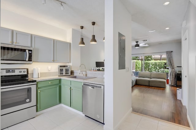 6936 Stoney Creek Cir, Lake Worth, FL 33467 - kitchen featuring stainless steel appliances, a sink, green cabinets, a ceiling fan, and light countertops